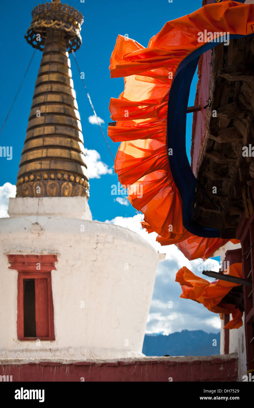 Buddhist stupa ( chorten ) and bright door curtain over blue sky at Buddhist Shey monastery. India, Ladakh, Shey Gompa Stock Photo