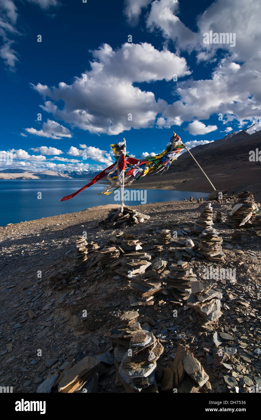 Sunset view at Tso Moriri Lake Stone pyramid and Buddhist praying flags Himalaya mountains landscape India Ladakh altitude 4600 Stock Photo