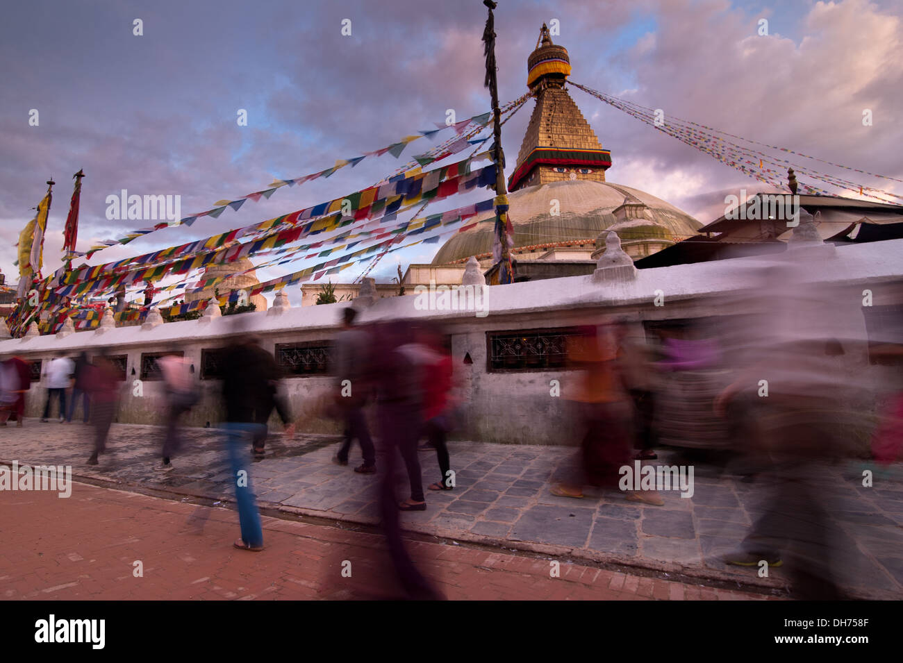 Kora. People walking around Buddhist shrine Boudhanath Stupa at sunset. Nepal, Kathmandu Stock Photo