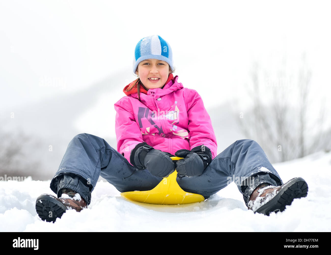 Happy girl in winter clothes on the snow Stock Photo