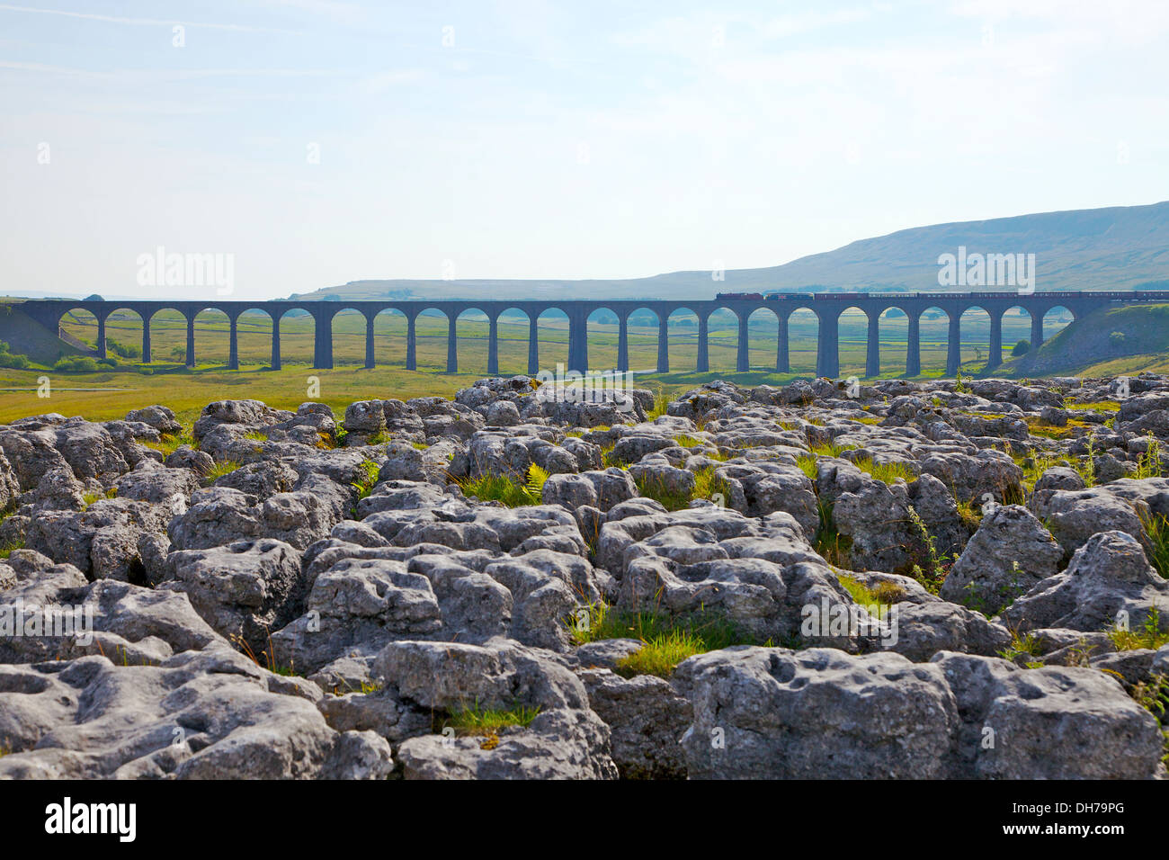 Steam train crossing Ribblehead Viaduct with limestone pavement in forground. Yorkshire Dales National Park North Yorkshire UK Stock Photo