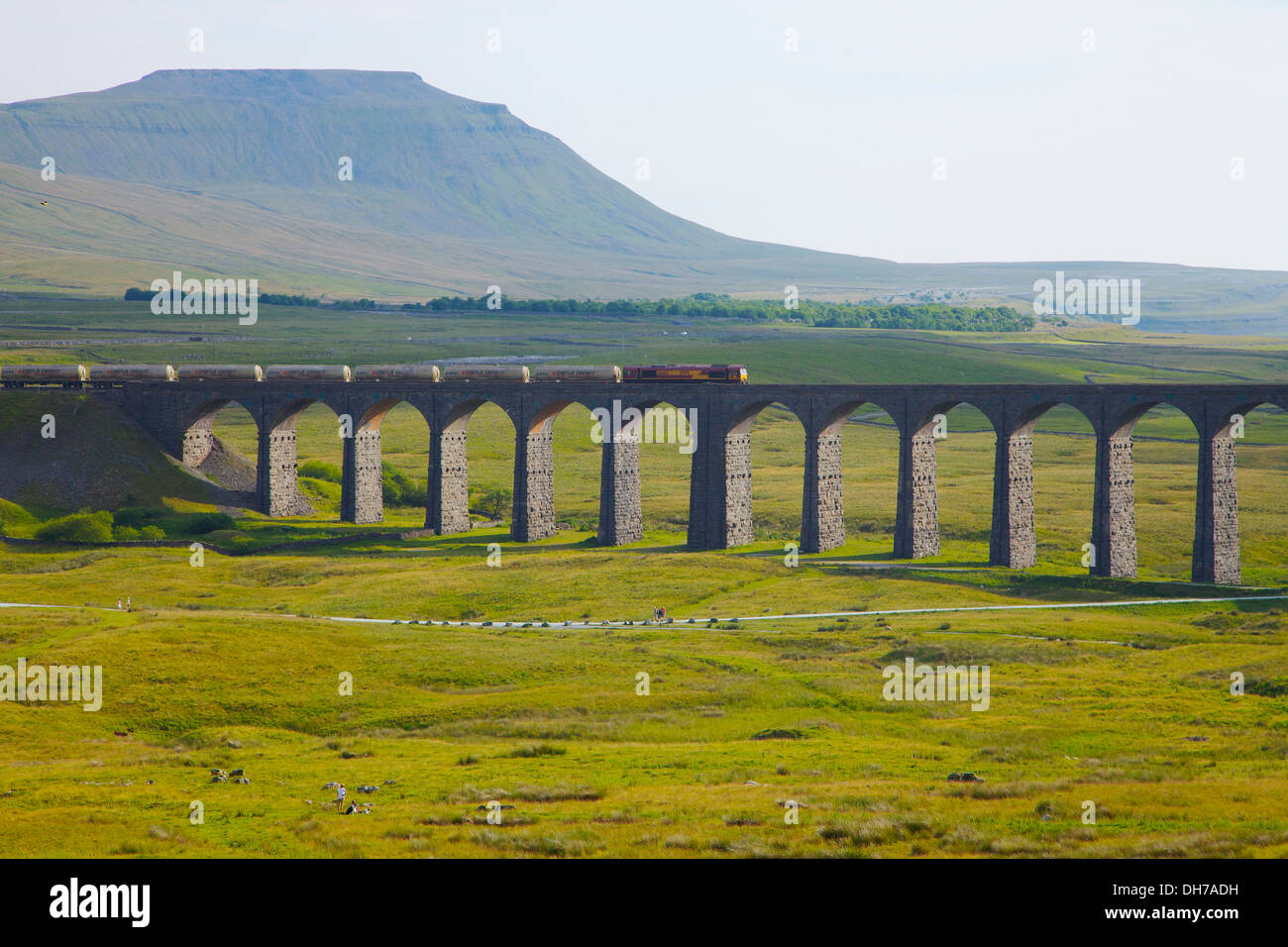 Freight train on Ribblehead Viaduct below Ingleborough mountain Yorkshire Dales National Park North Yorkshire England UK Stock Photo