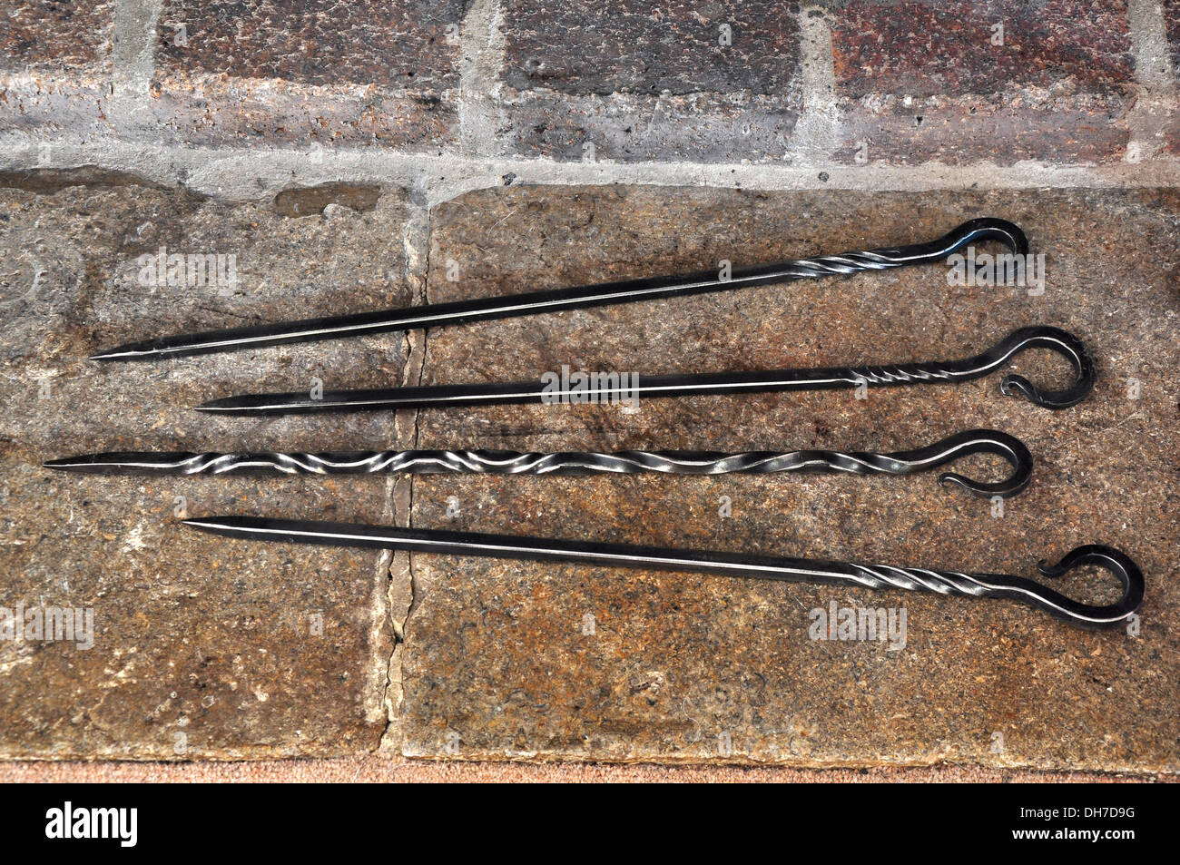 Four iron fire pokers on a stone hearth UK Stock Photo Alamy