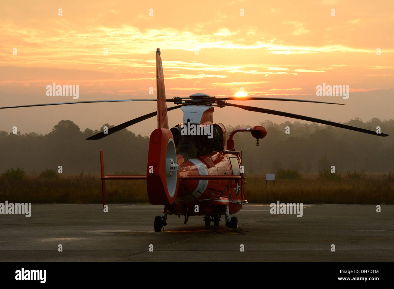 An MH-65 Dolphin helicopter sits at sunrise at Coast Guard Air Station Atlantic City, N.J., Thursday, Oct. 31, 2013. Air Station Atlantic City aircrews utilize the MH-65 Dolphin helicopter for search and rescue, law enforcement, and national security miss Stock Photo
