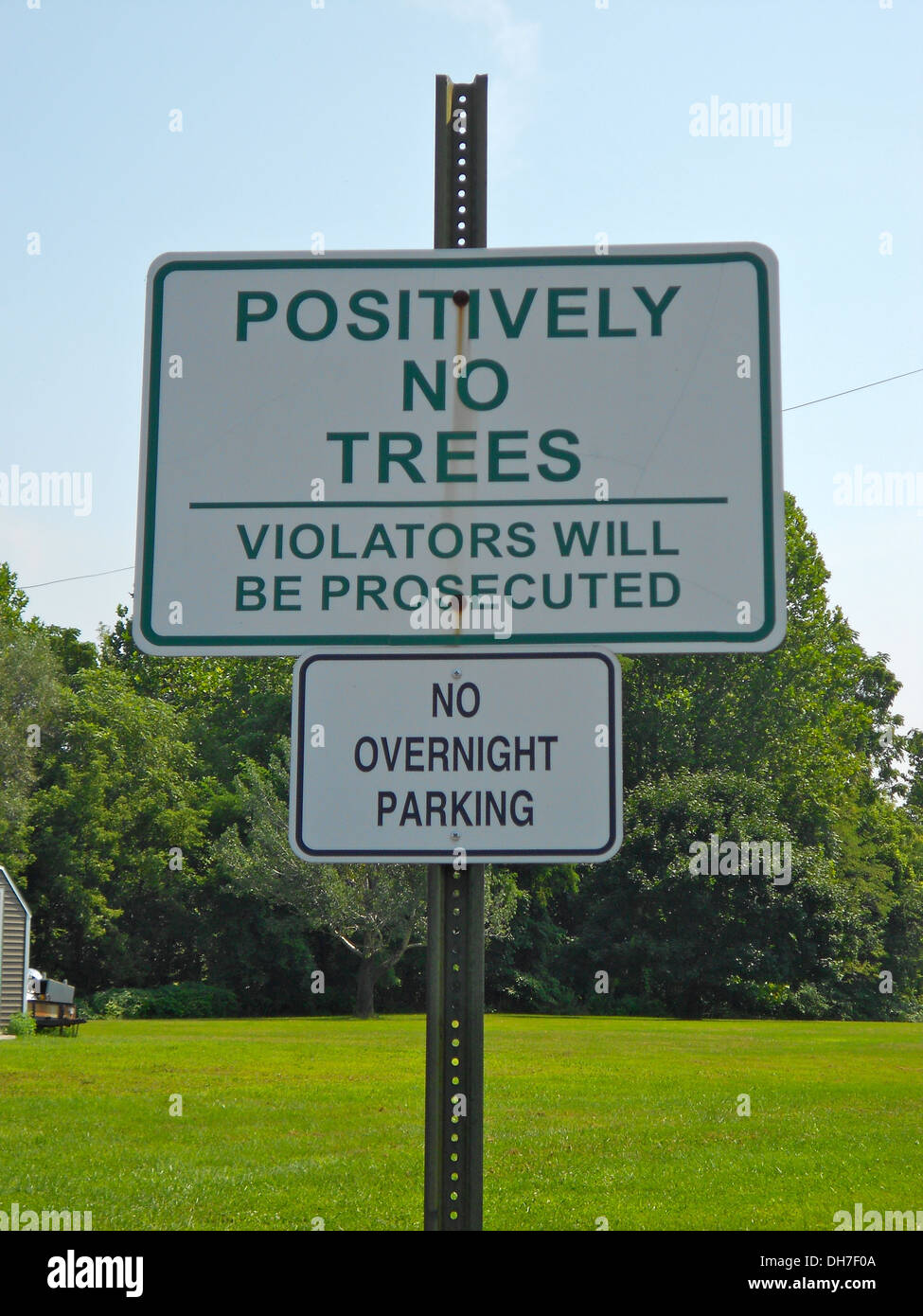 Sign in Leesport, Pennsylvania reading 'Positively No Tree, Violators will be prosecuted' and below 'no overnight parking'. It is located in Leesport, PA next to the Fire Dept. in a small parking lot extension. On the other side is a Post Office and acros Stock Photo
