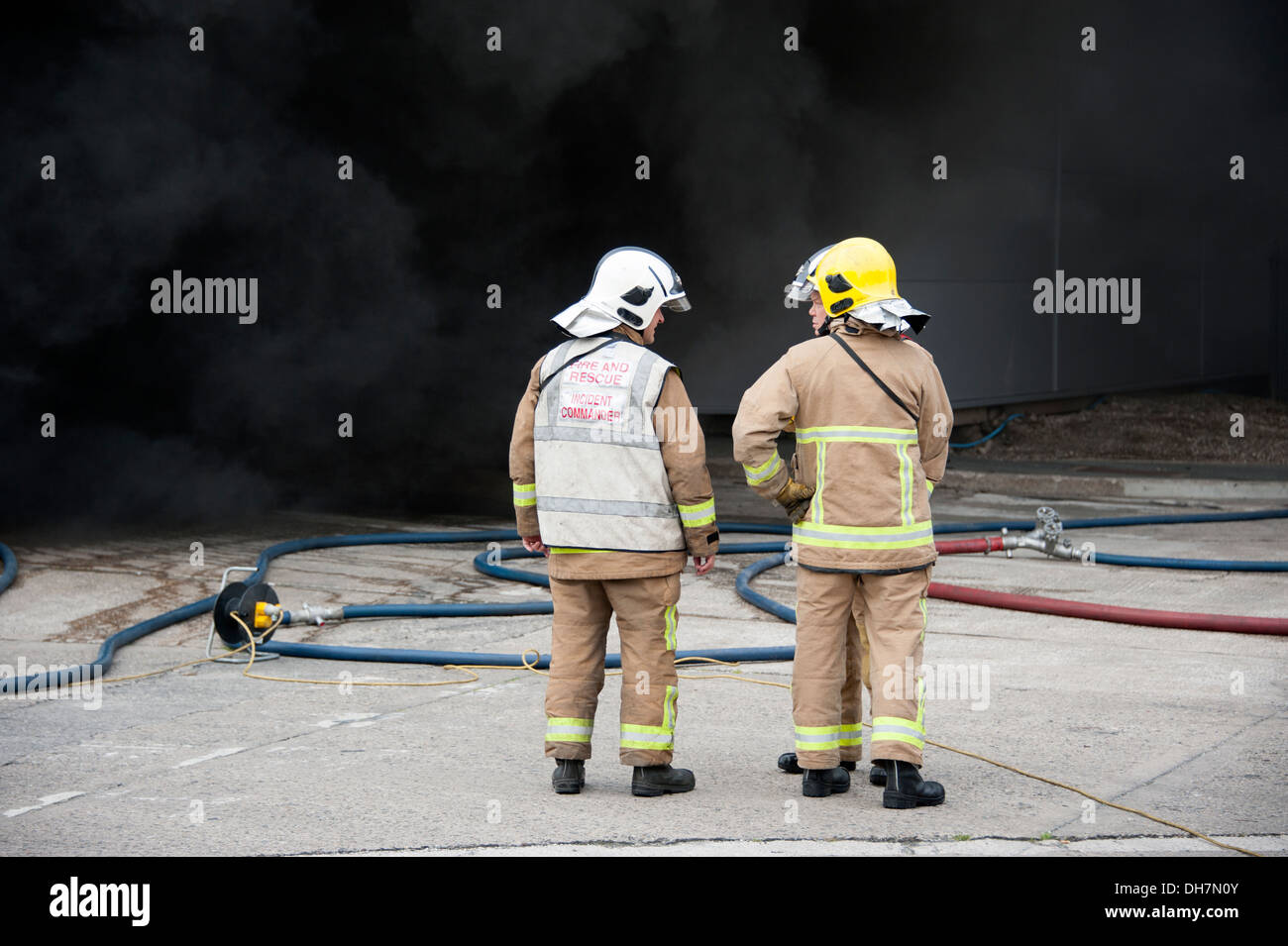 2 Firemen Firefighters thick smoke Incident Commander Stock Photo