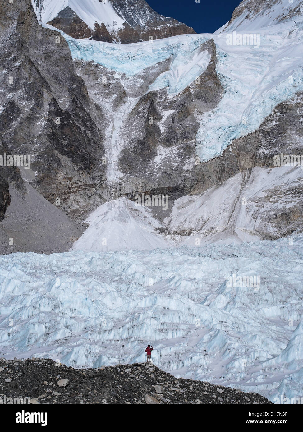 A trekker standing in front of the massive Khumbu Glacier near Everest Base Camp in Nepal. Stock Photo