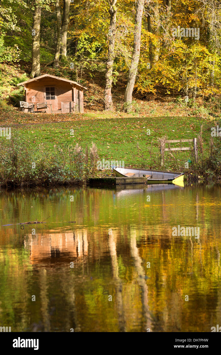 English Landscape, lakeside scene amid autumn woodland with  beautiful reflections, rowing boat. Stock Photo