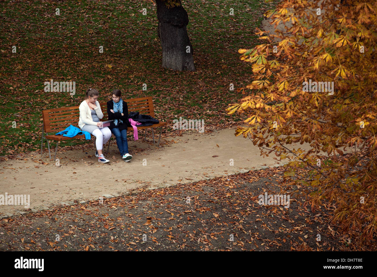 Two girls on a bench in the park, Prague autumn Strelecky Ostrov Prague park Czech Republic Stock Photo
