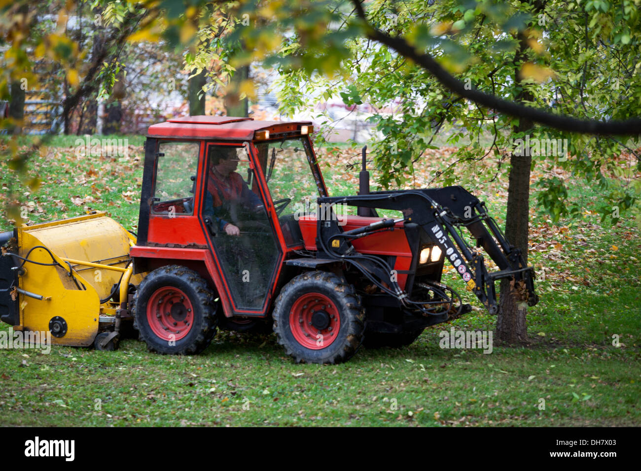 Small tractor cleaning of fallen leaves in the City park, Prague Czech Republic Stock Photo