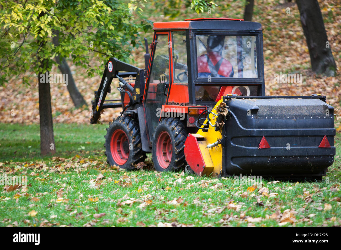 Small tractor cleaning of fallen leaves in the City park, Prague Czech Republic Stock Photo