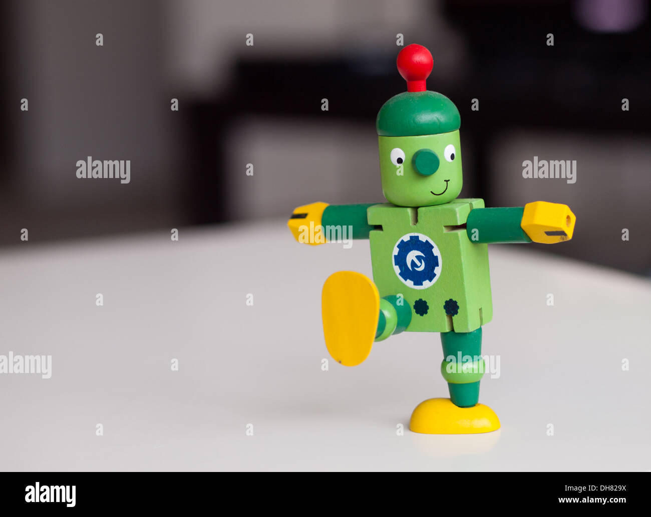 A happy, cute, wooden toy robot, marching. Stock Photo
