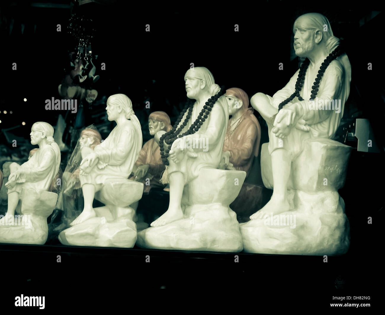 Small statues of saint Saibaba are kept for sell in a shop at marketplace. Shirdi, Maharashtra; India Stock Photo
