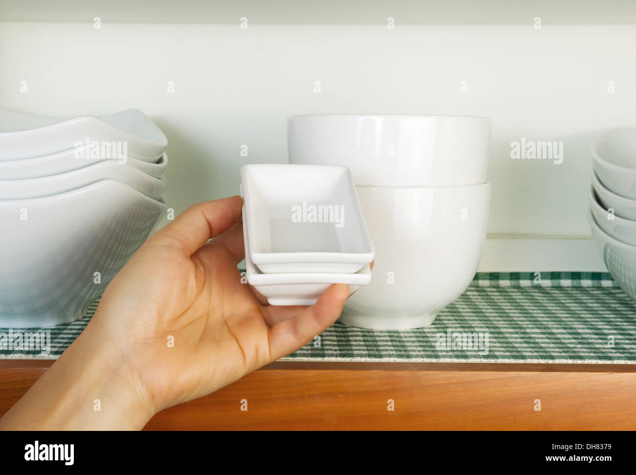 Horizontal Photo Of Female Hand Putting Small Square Dishes Back
