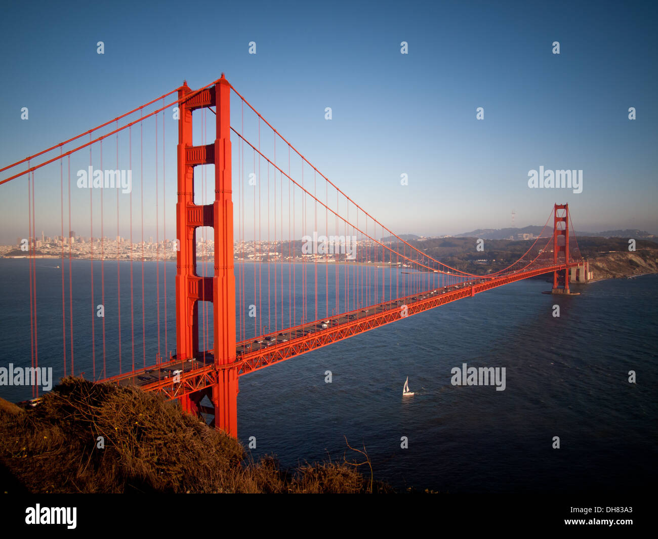A lone sailboat sails under the peerless Golden Gate Bridge in San Francisco, California. Stock Photo