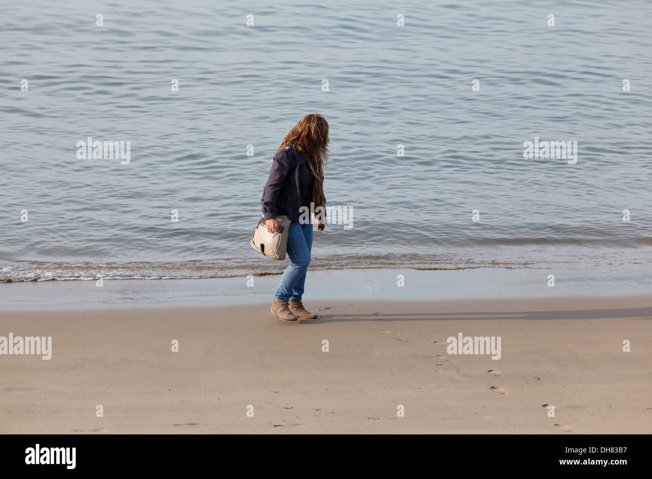 Woman walking on beach in winter - California USA Stock Photo