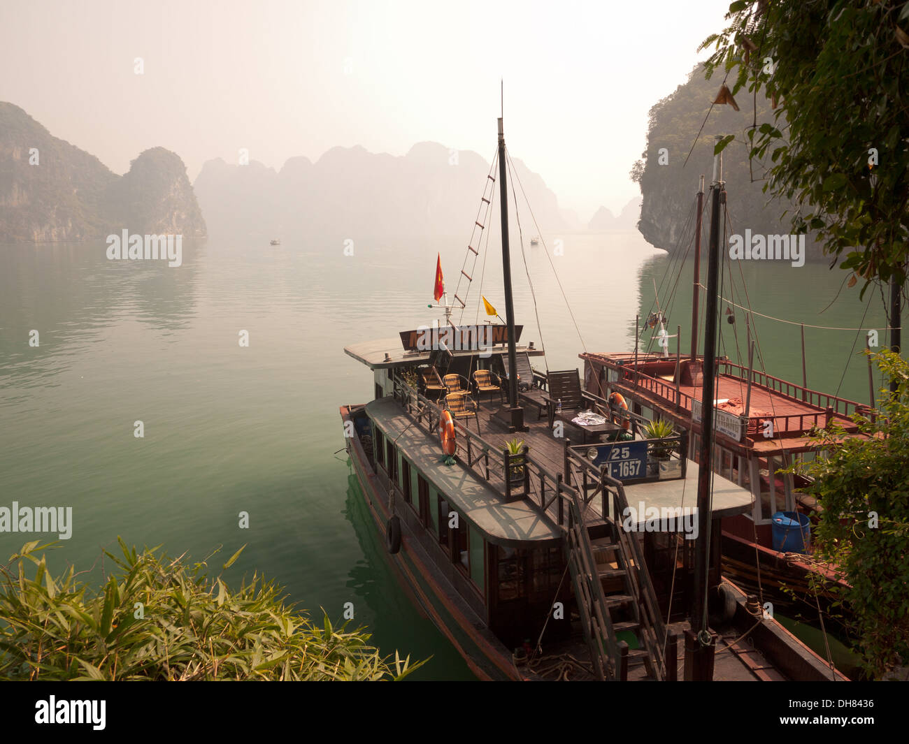 A view of the spectacular limestone karst formations and boats moored  in Halong Bay, Vietnam. Stock Photo