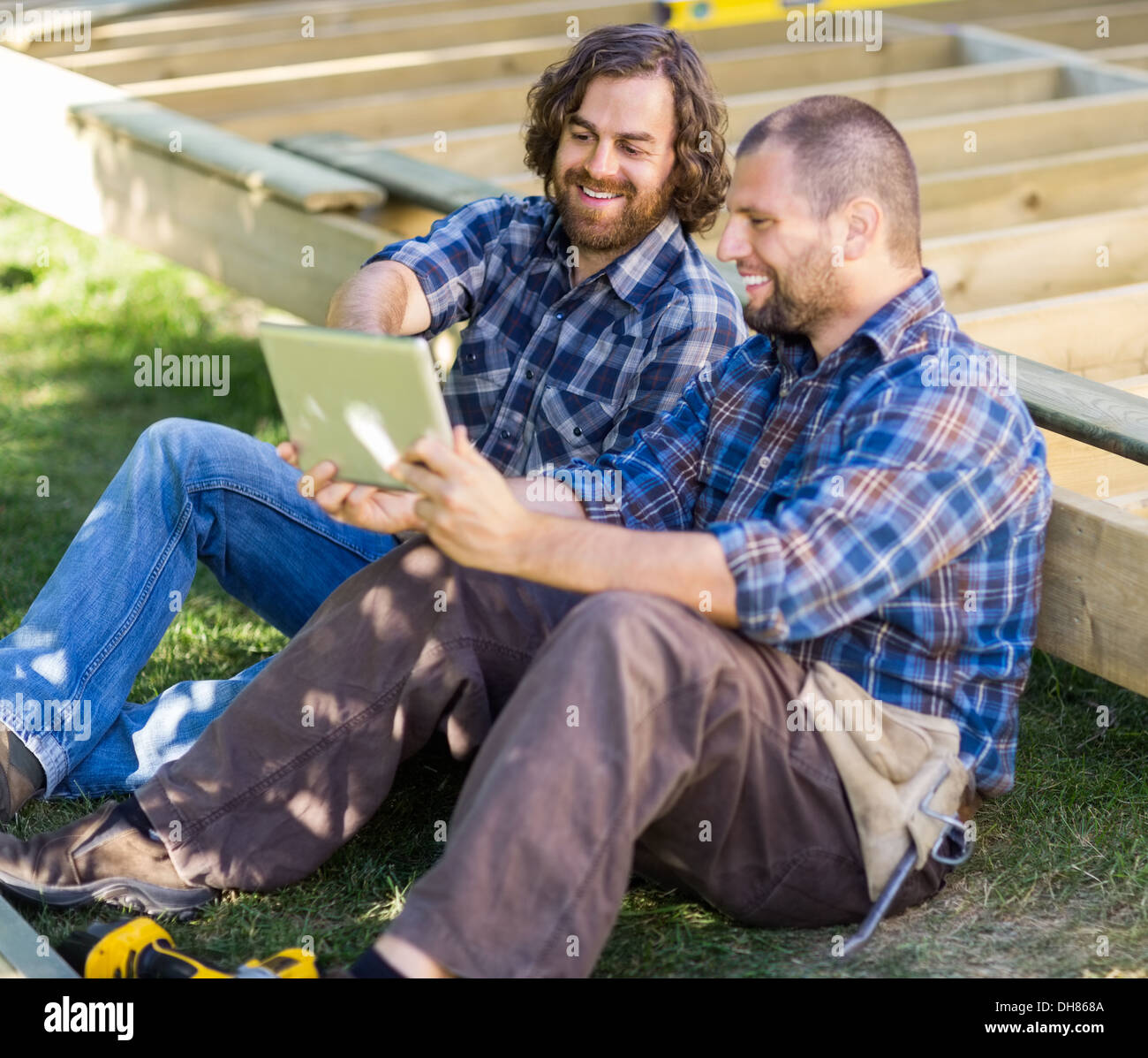Happy Carpenters Using Digital Tablet At Construction Site Stock Photo