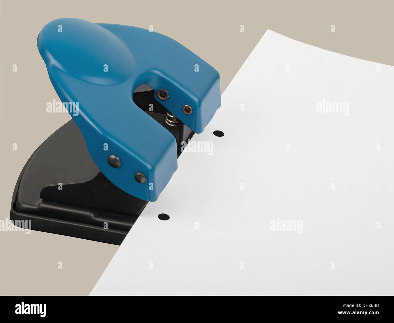 drilling hole punch with paper, studio shot Stock Photo