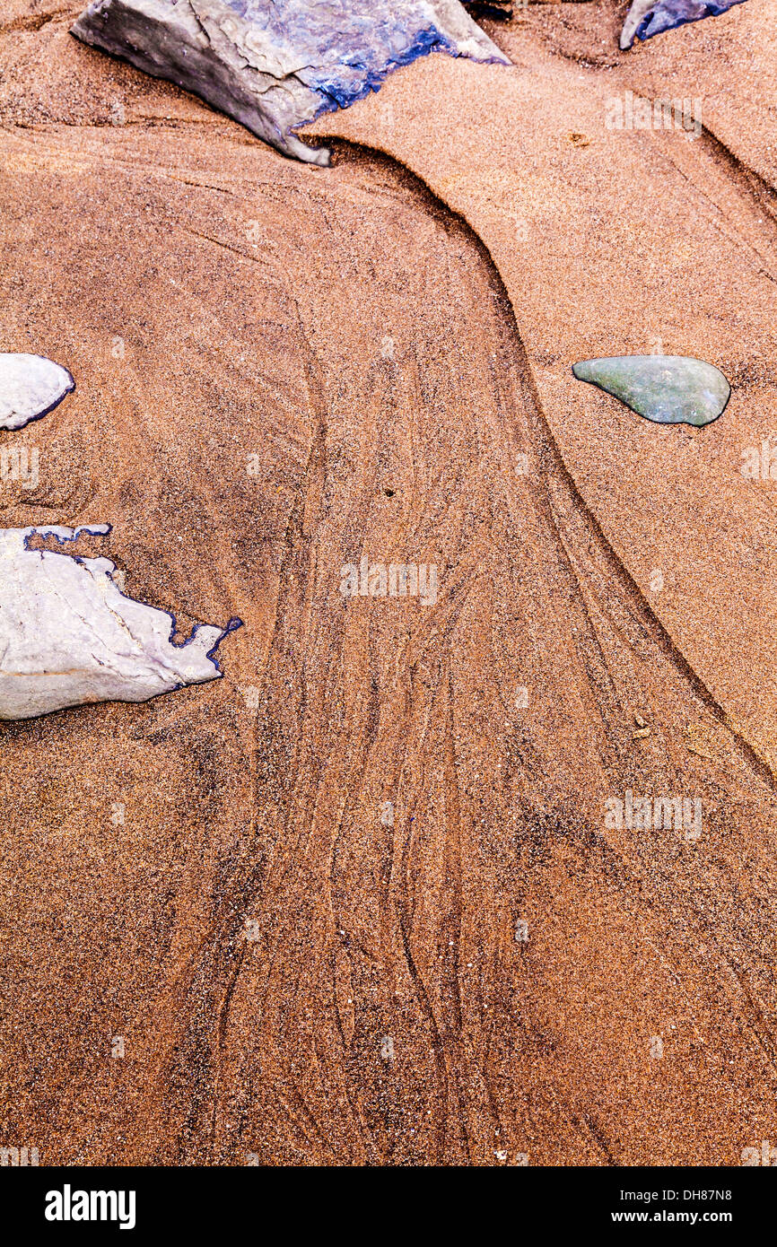 An abstract image of rocks and sand forming patterns on the beach at Nash Point in Wales. Stock Photo