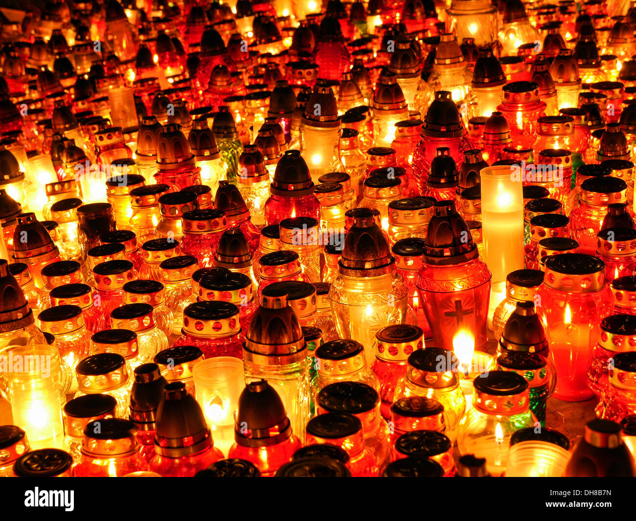 Bunch of glass votive candles lit in the dark Stock Photo