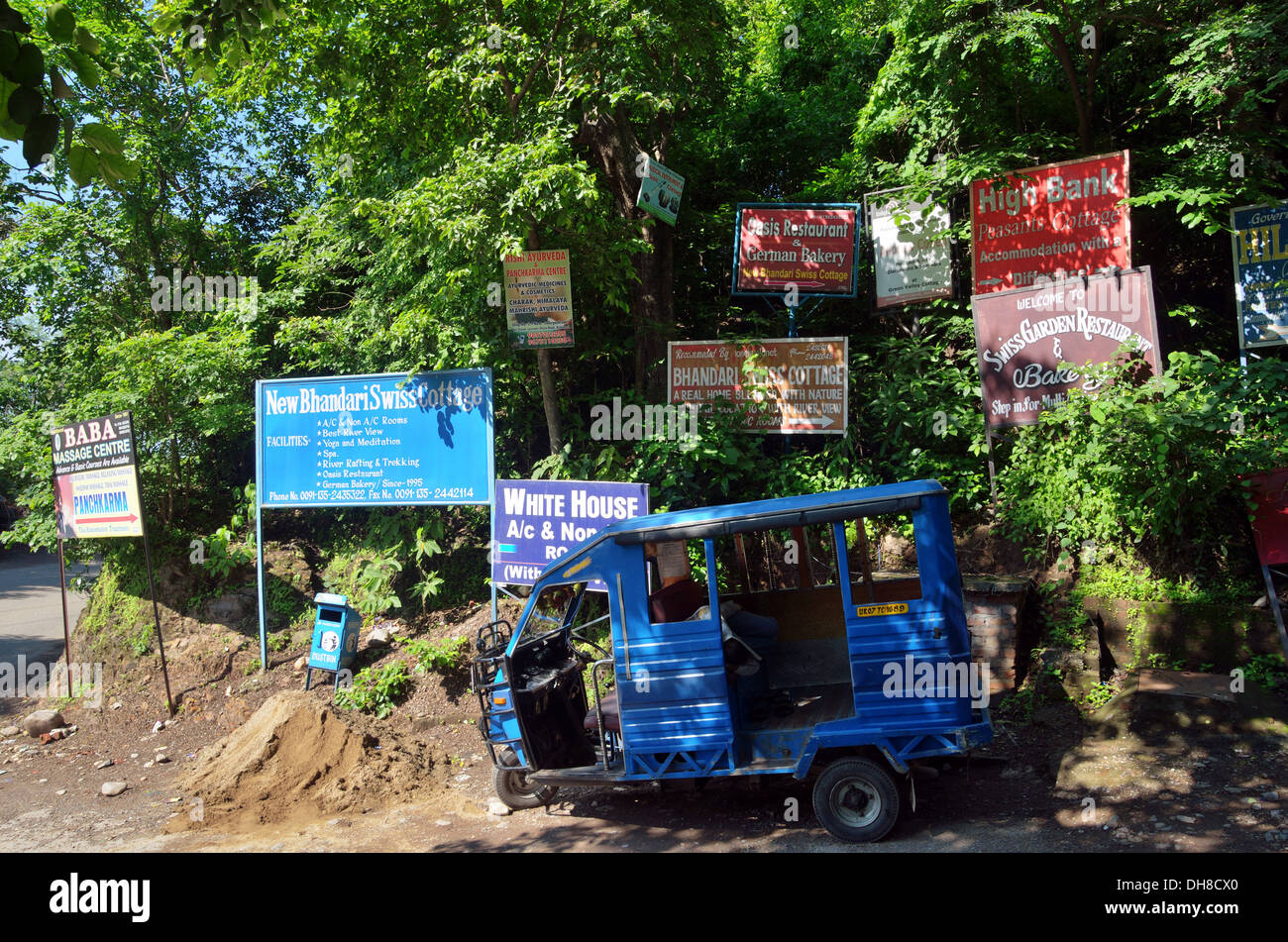 Auto rickshaw parked against advertising boards, High Bank area, Rishikesh, India Stock Photo