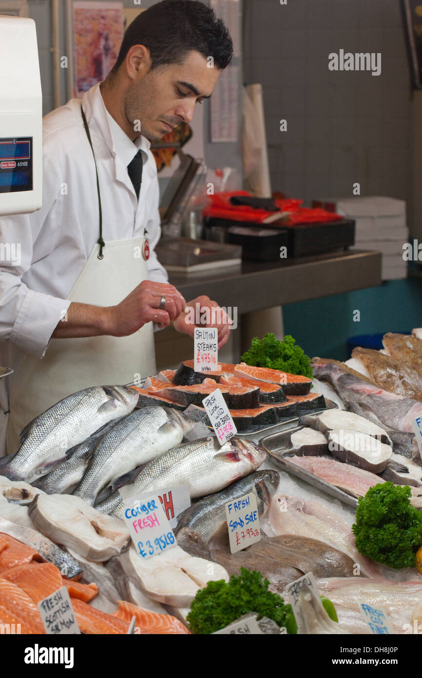 Fish Monger and stall of wares. Beresford Fish Market. Beresford Street, St. Helier, Jersey, Channel Islands. England. UK. Stock Photo