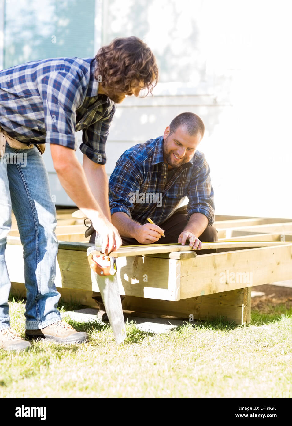 Workers Measuring Wood At Construction Site Stock Photo - Alamy