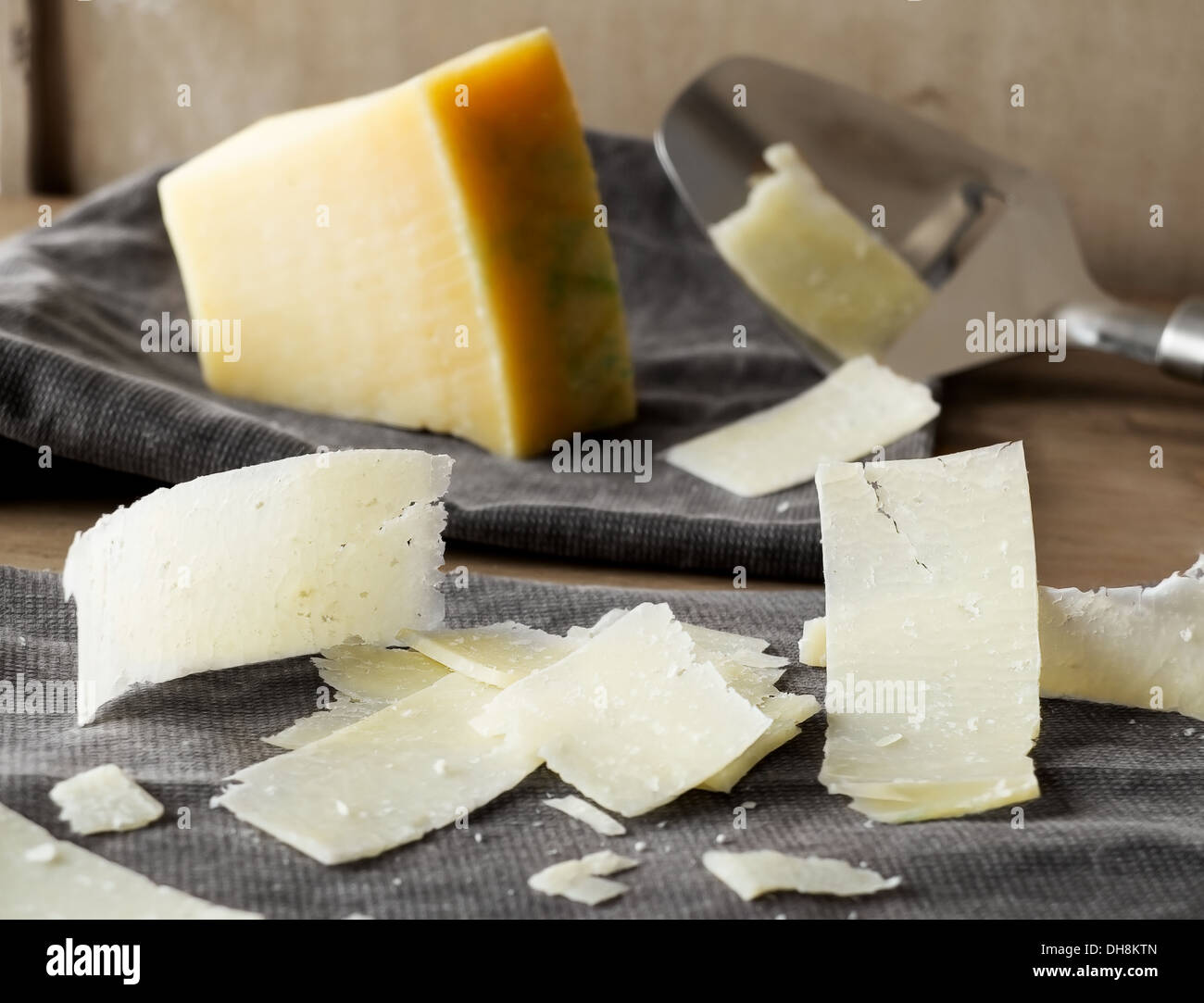 Parmesan cheese slices on a rustic fabric. Stock Photo