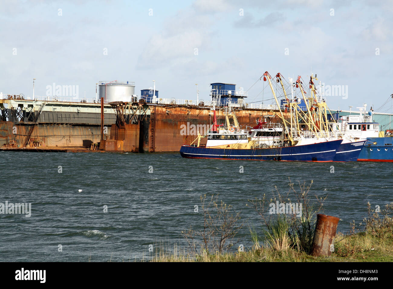Fishing boats lying at a dry dock for repairs at the port of Lauwersoog Stock Photo