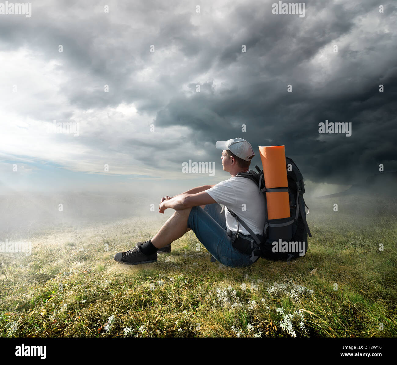 Tourist resting on the hill under storm clouds Stock Photo