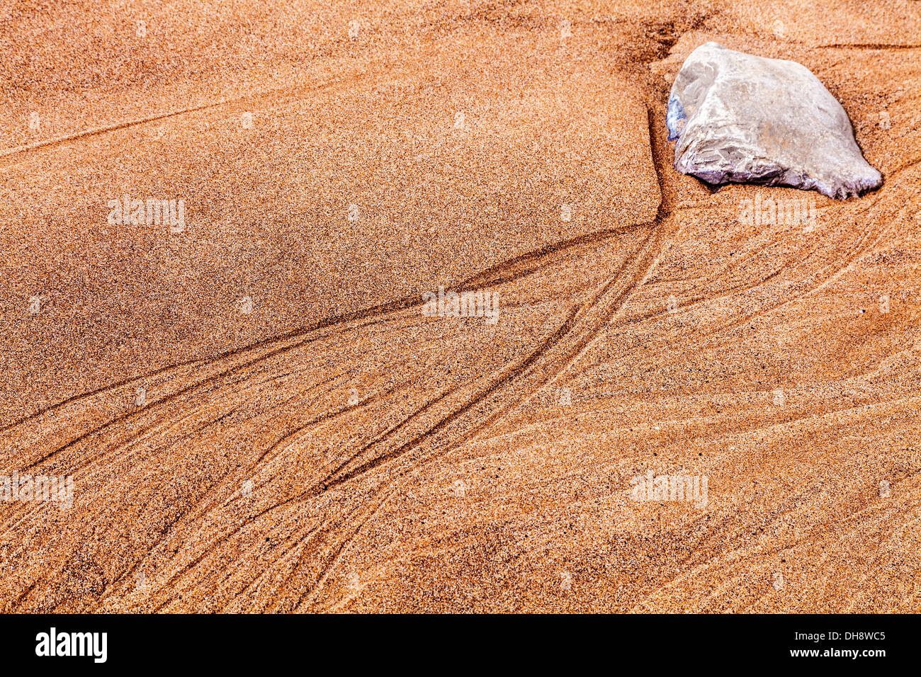 An abstract image of a rock and sand ripples forming patterns on the beach at Nash Point in Wales. Stock Photo