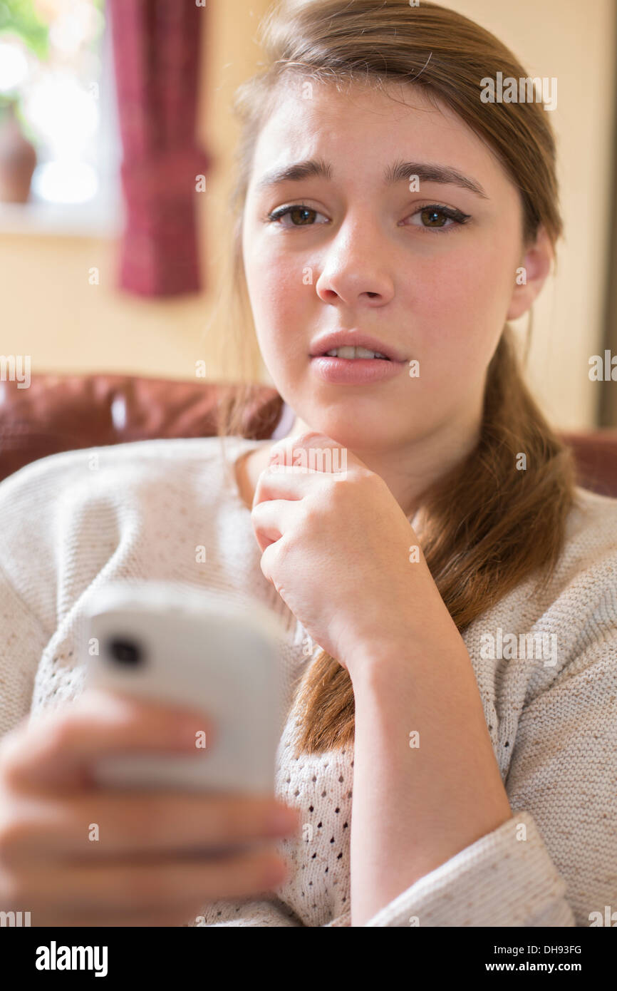 Scared Teenage Girl Being Bullied By Text Message Stock Photo