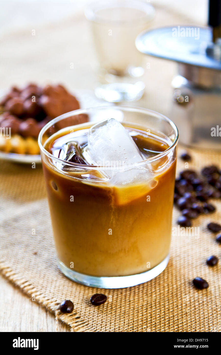 Ice coffee in glass mug with milk and cinnamon on wooden table in the  garden Stock Photo - Alamy