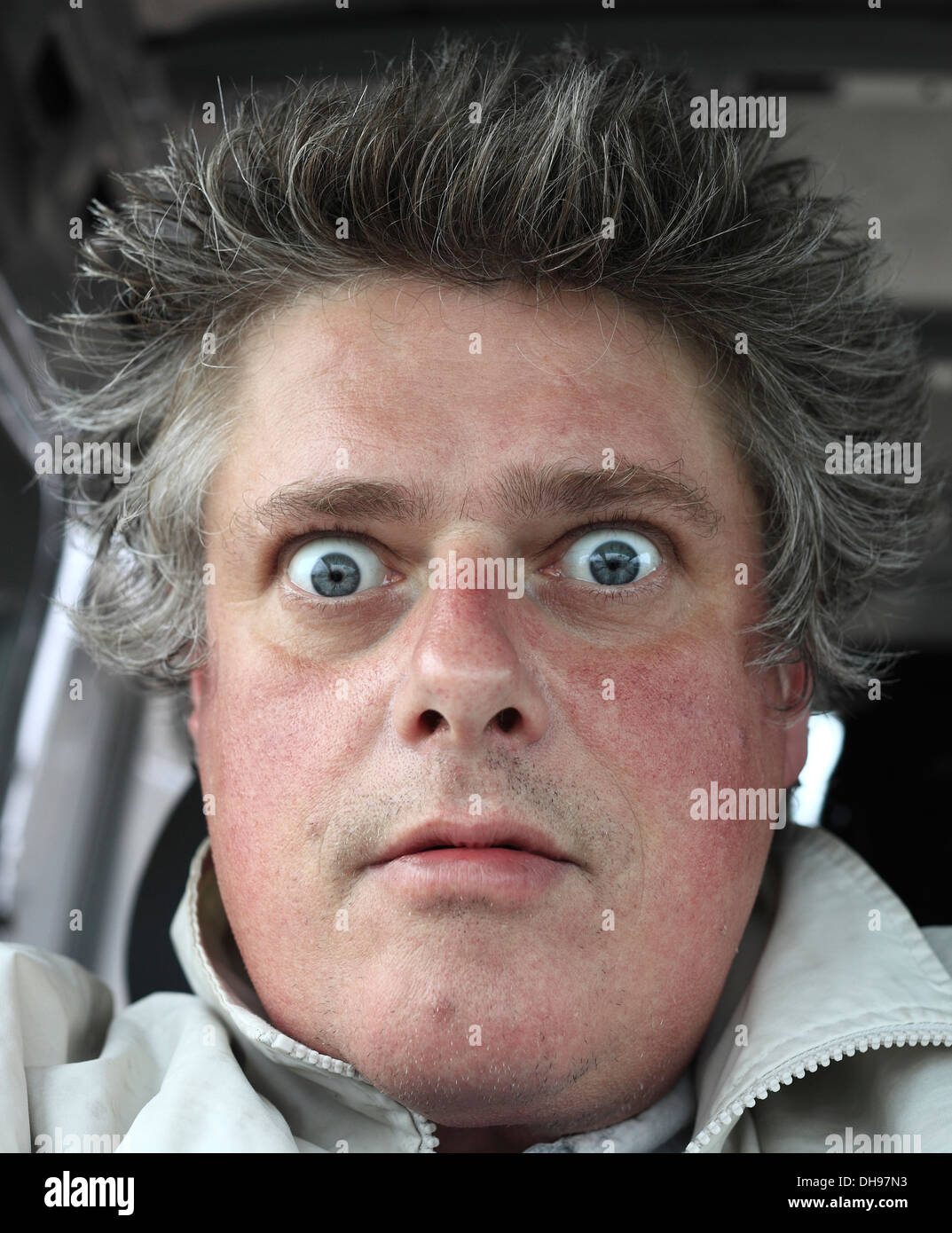 Wide eyed, odd expression on the face of a middle aged white male. Stock Photo