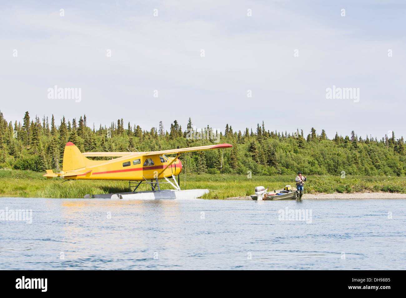A Sport Fisherman Angling For Sockeye Salmon by A  De Havilland Beaver Floatplane And A Small Riverboat, The Kvichak River Stock Photo