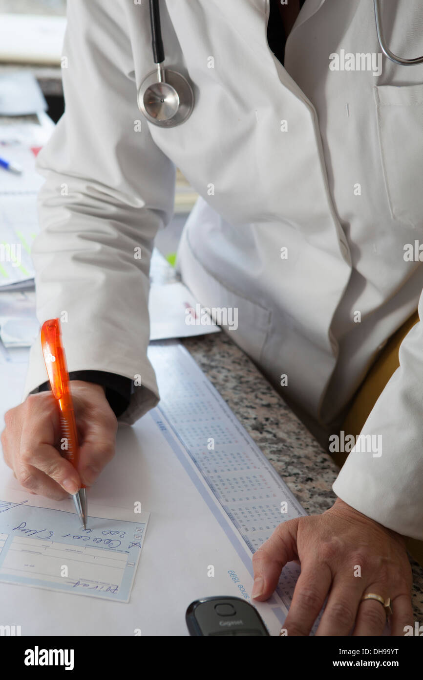 Doctor writes a sick note Stock Photo