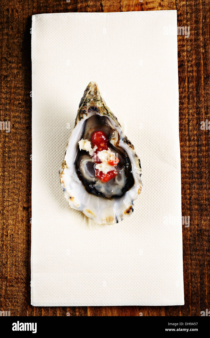 Raw oyster on the half shell with horseradish and cocktail sauce on top