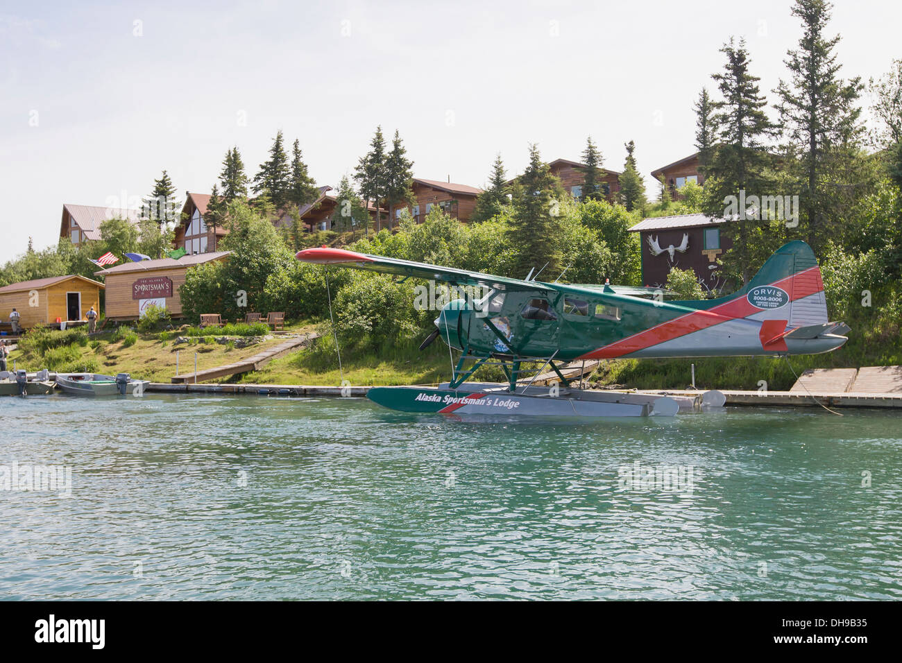 A Floatplane Is Docked At Alaska Sportsman's Lodge. In The Background Fishing Boats And Cedar Buildings  On The Kvichak River. Stock Photo