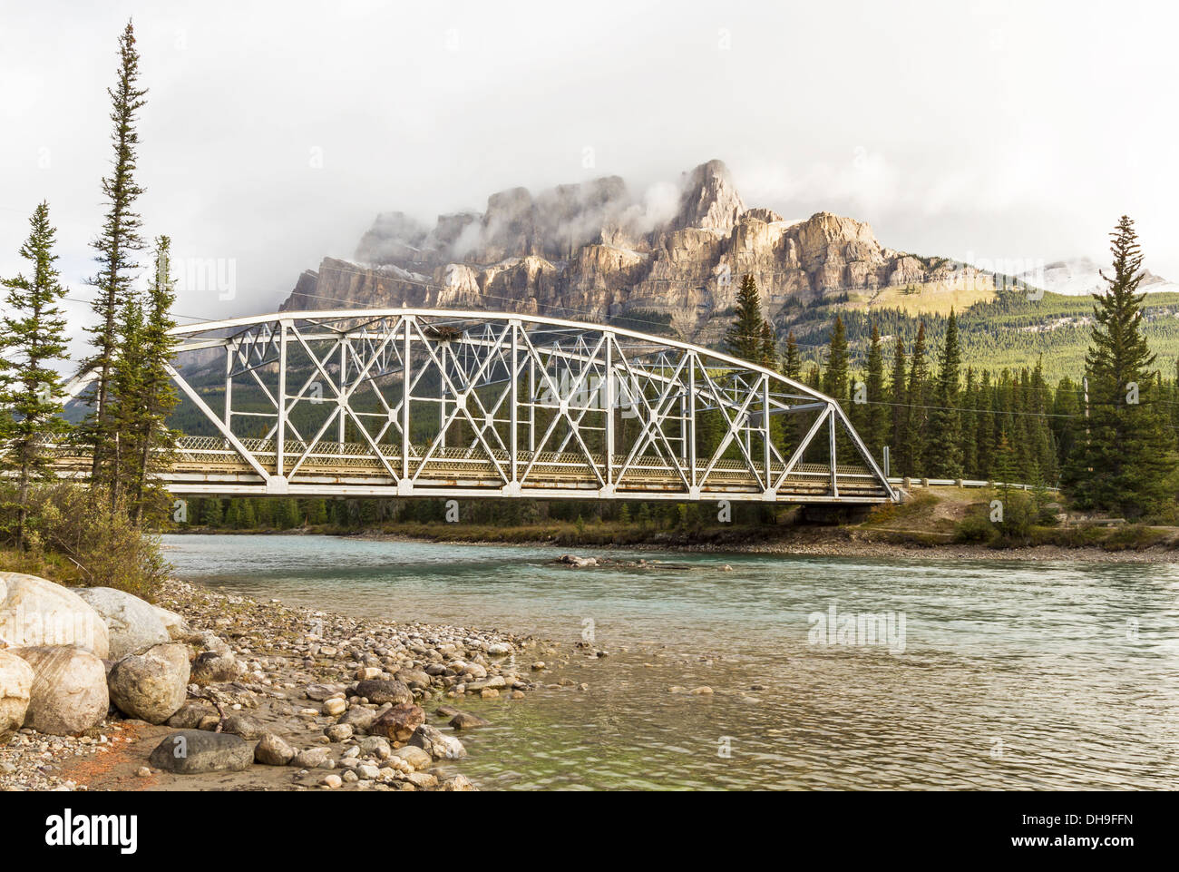 Castle Mountain emerges from the clouds above a bridge over the Bow River in Banff National Park, Alberta Stock Photo