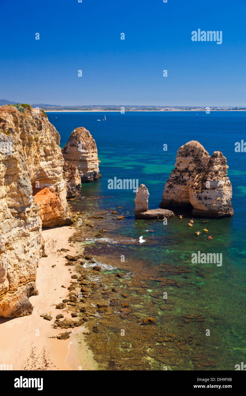 Six canoeists paddling towards the empty sandy beach at Praia da Camilo Lagos Algarve Portugal EU Europe Stock Photo