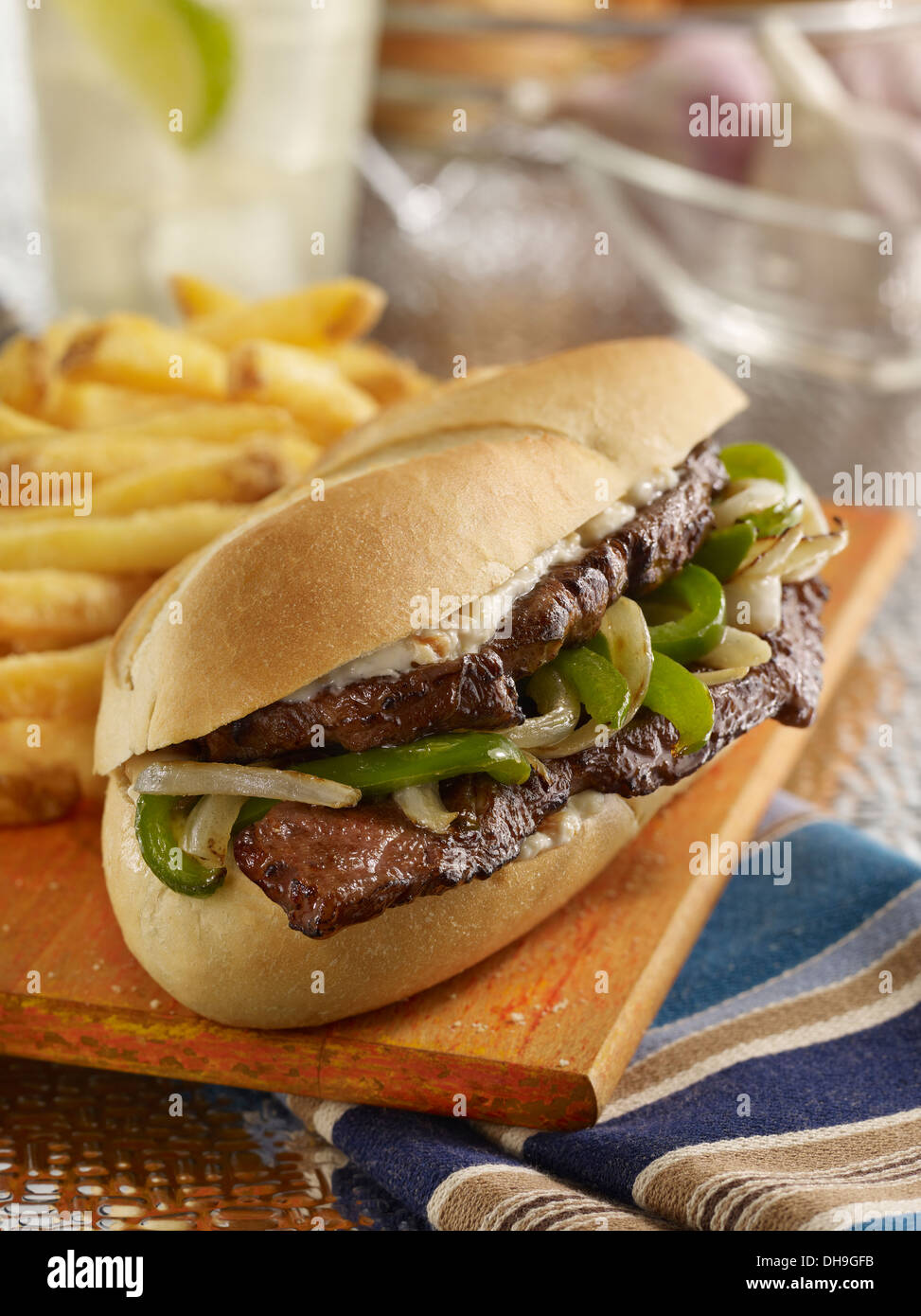 Steak Sandwich with grilled peppers and onions and French fries Stock Photo