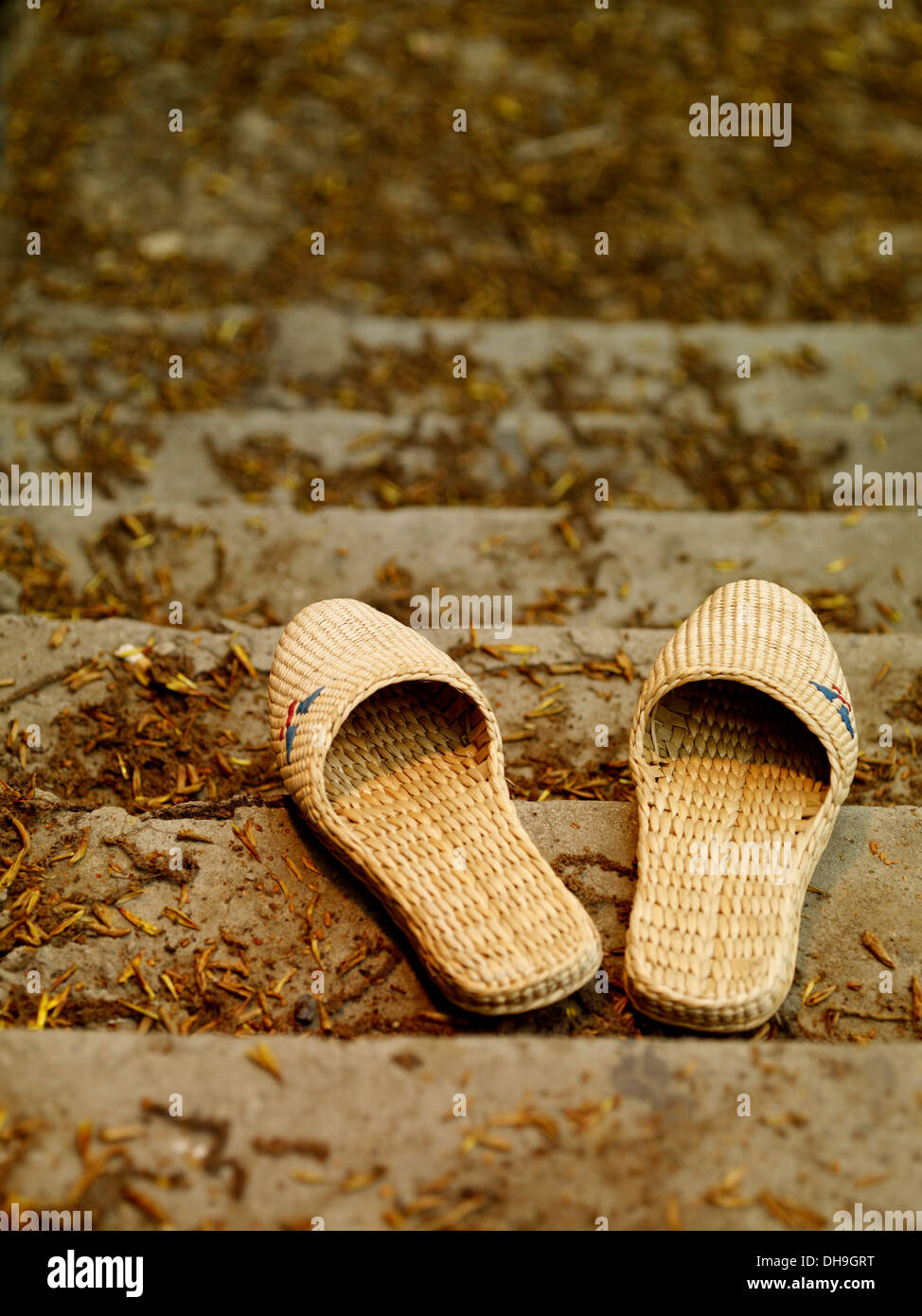 A pair of straw sandals on the stairs Stock Photo