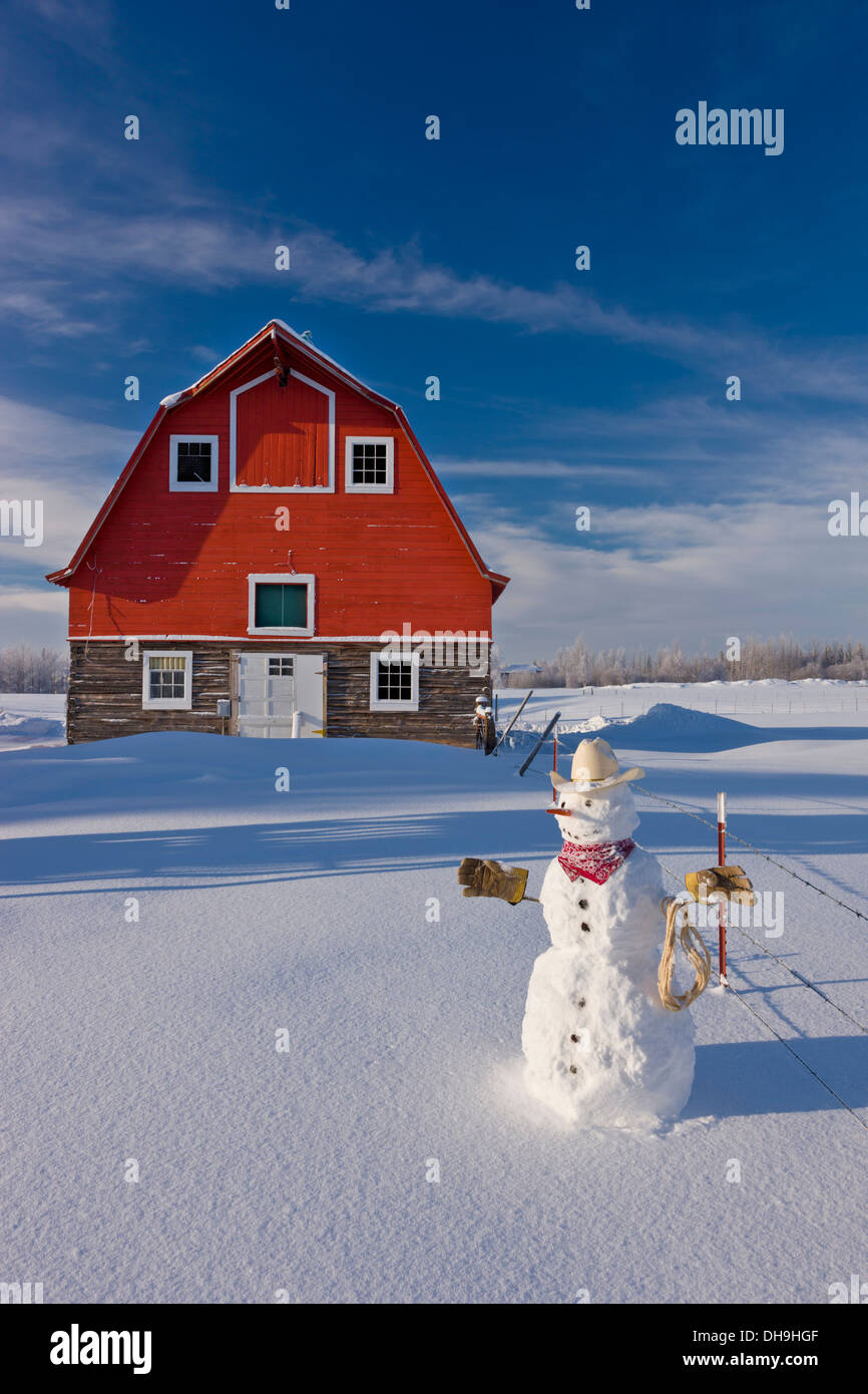 Snowman Dressed Up As A Cowboy Standing In Front Of A Vintage Red Barn