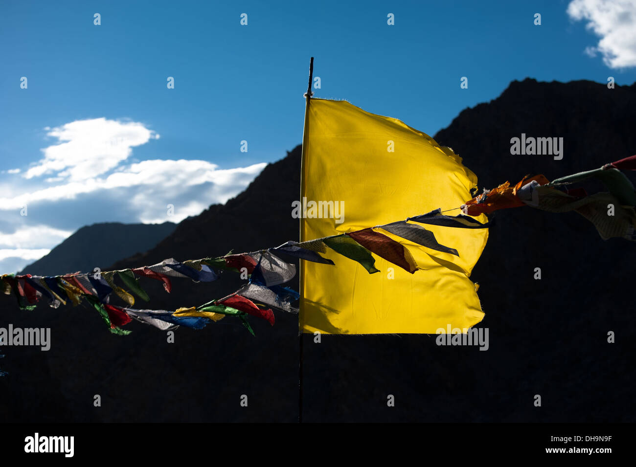 Buddhist praying flags flapping in wind over Himalaya mountains landscape and blue sunset sky India Ladakh Leh altitude 3300 m Stock Photo