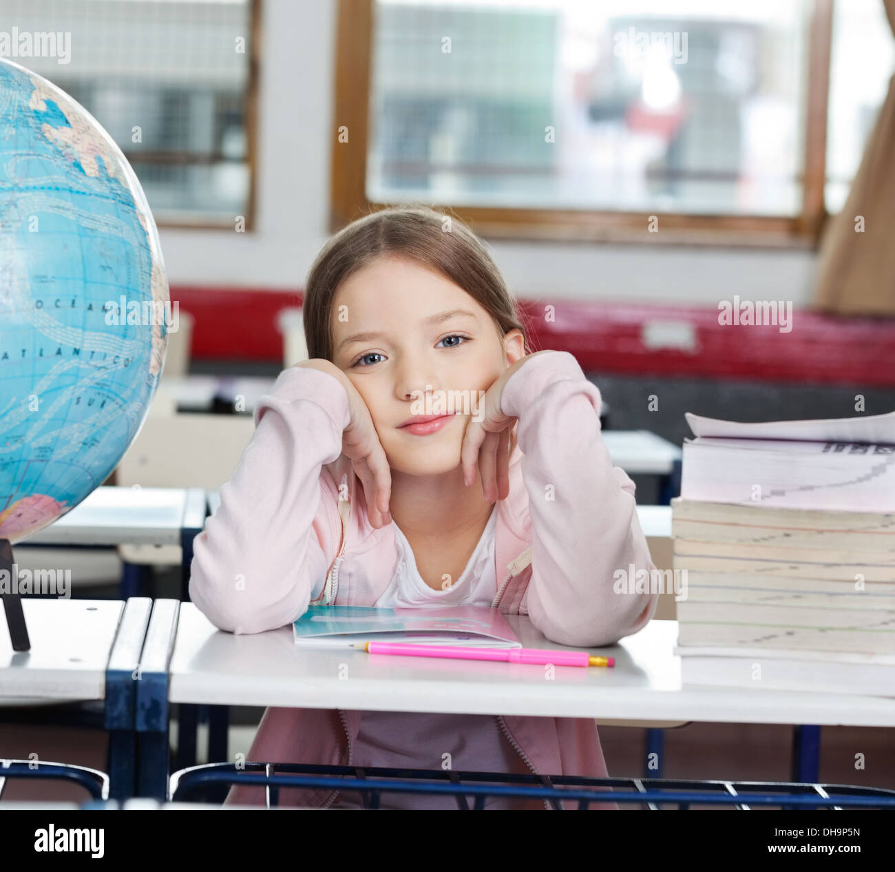 Schoolgirl With Stack Of Books And Globe At Desk Stock Photo - Alamy