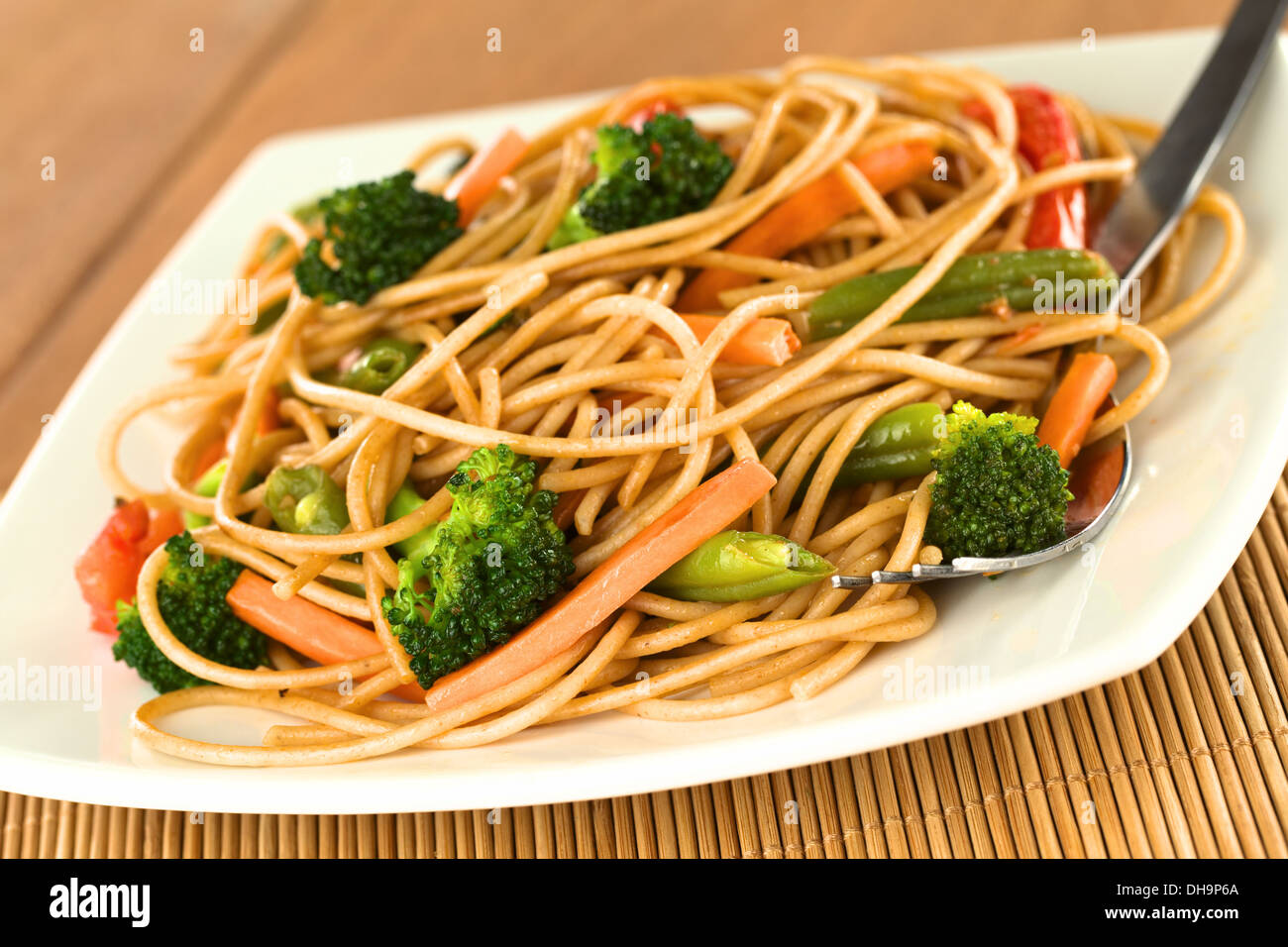 Vegetable and wholewheat spaghetti stir fry with fork (Selective Focus