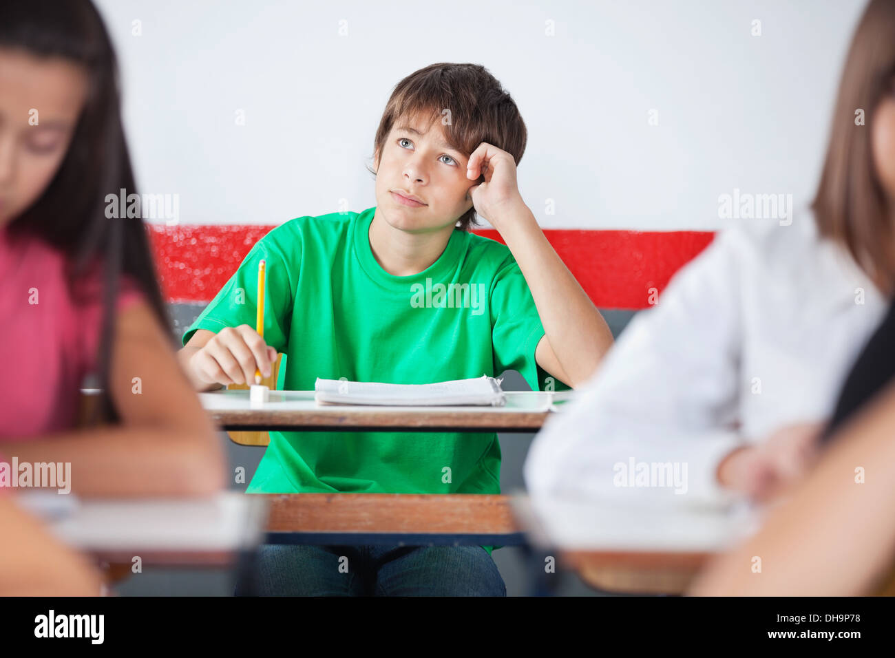 Thoughtful Teenage Schoolboy Sitting At Desk Stock Photo - Alamy
