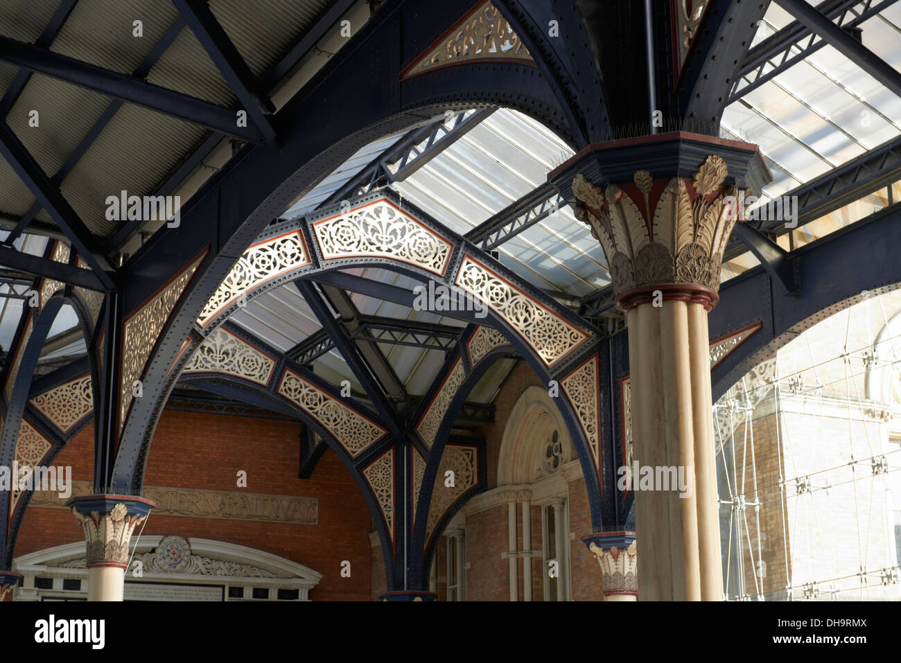Architectural detail of the cast iron roof structure of London Liverpool Street station with light shining through the glazed roof of the Victorian Stock Photo