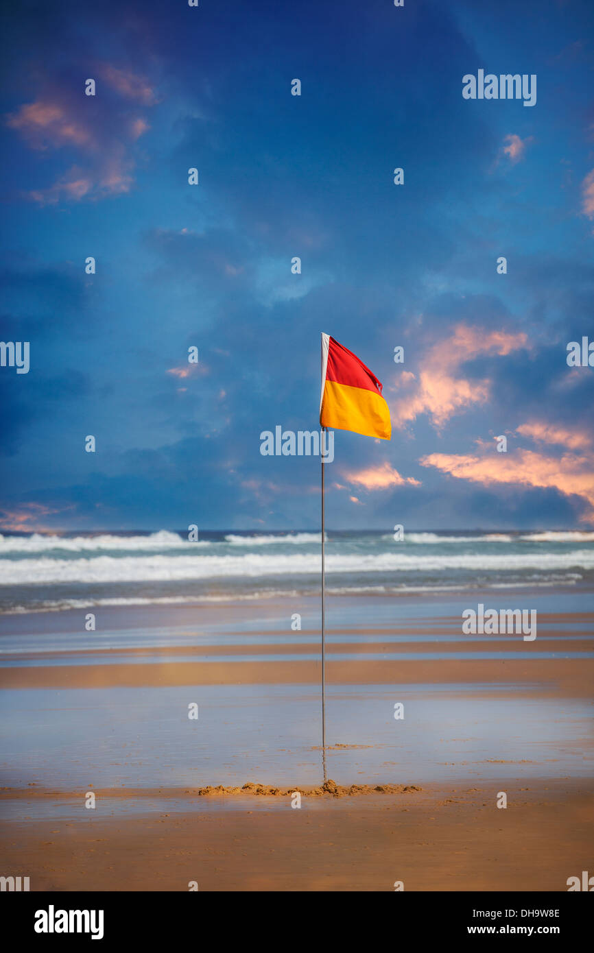 A color photograph of a swimming awareness flag on a beach in Queensland, Australia. There are no people in the photograph. Stock Photo